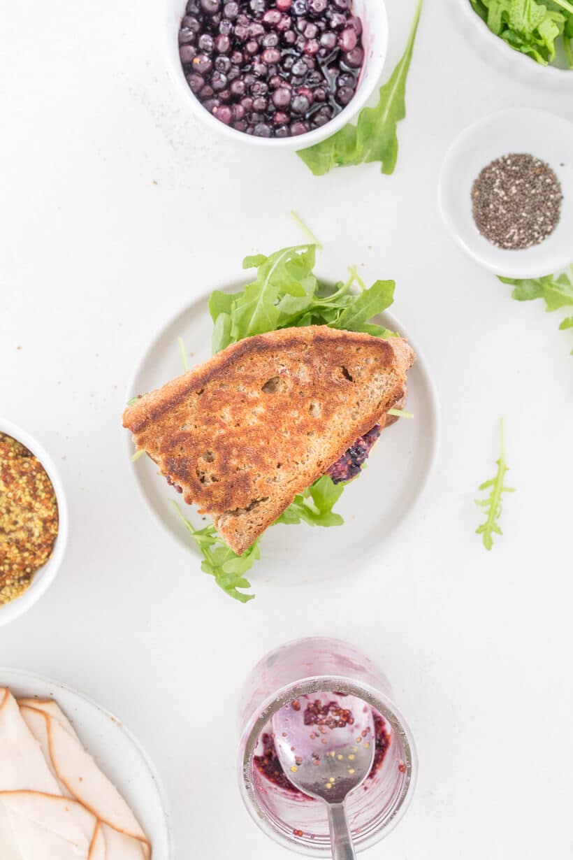 turkey and brie sandwich with other ingredients next to it on a table