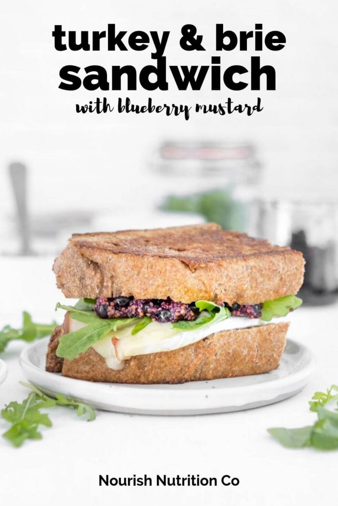 turkey and brie sandwich with blueberry mustard and arugula with text overlay