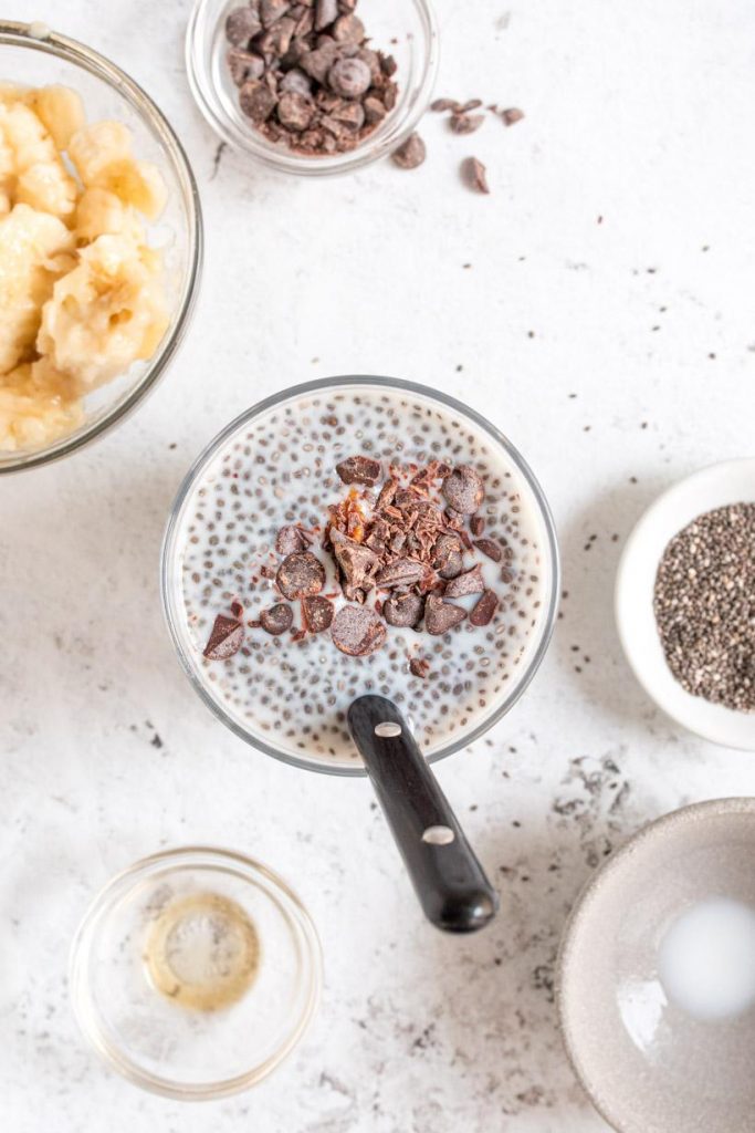 chia pudding with bananas, peanut butter, and chocolate chips on top in a glass