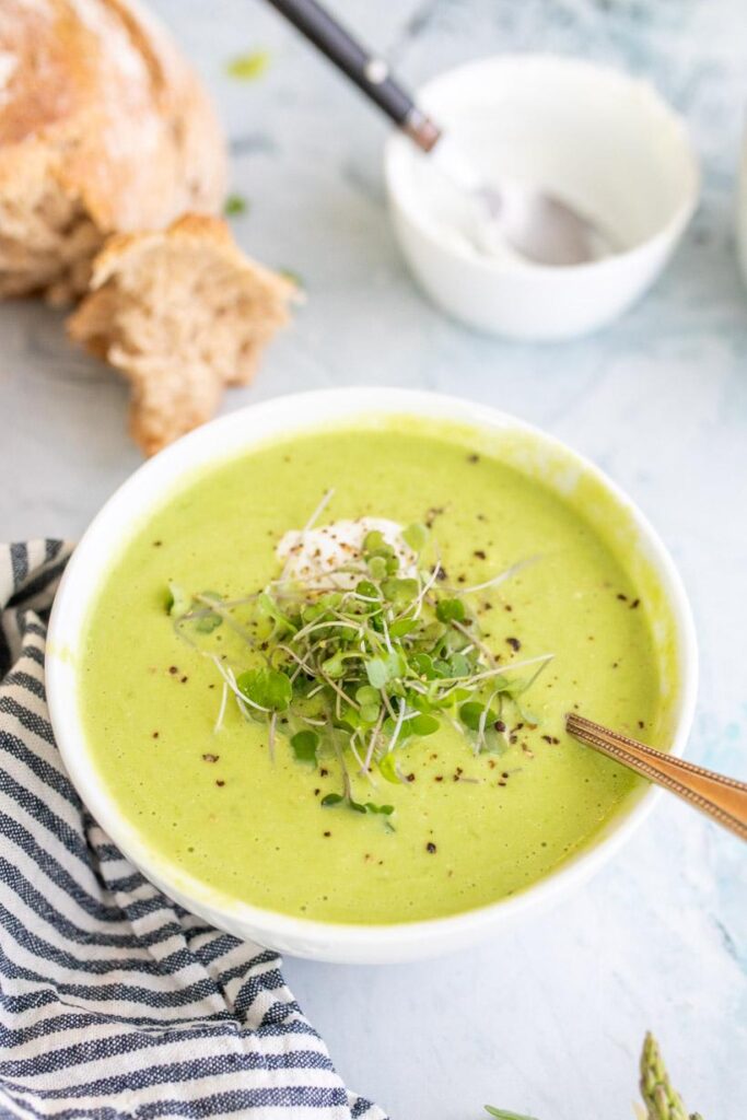 creamy asparagus soup in a white bowl