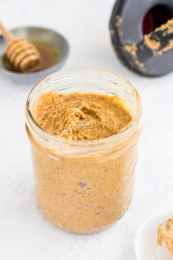 honey almond butter with salt on top in a glass jar on table