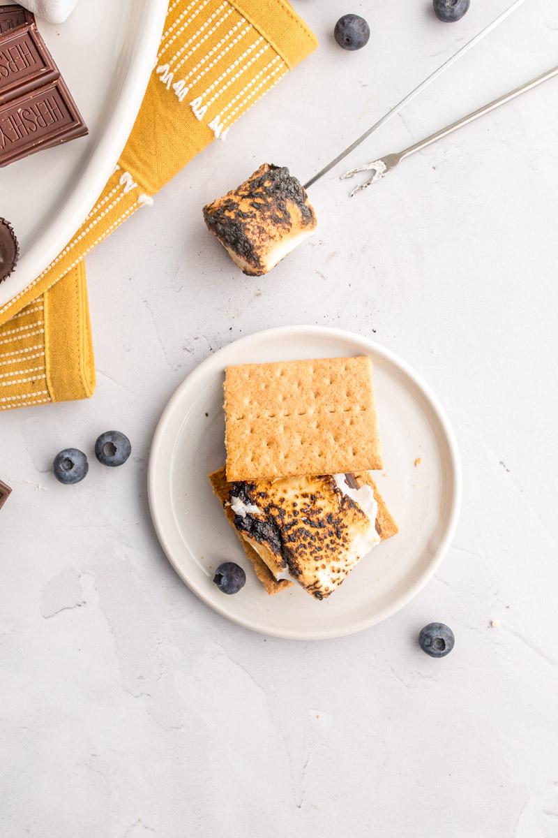 one smore on a table with ingredients around it