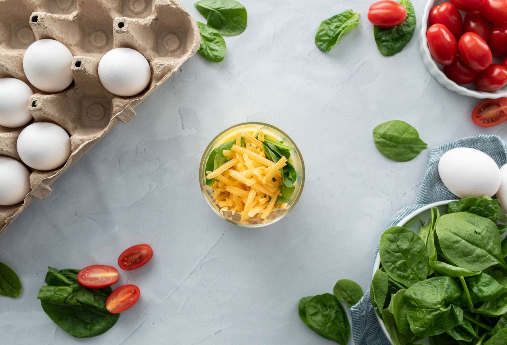 microwave egg bowl on a table with a fork and ingredients