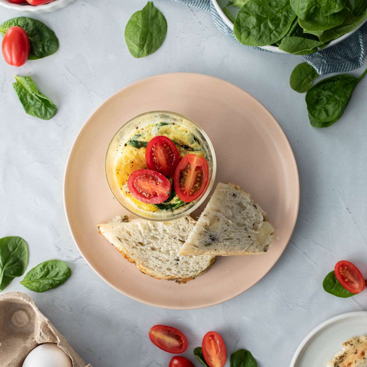 close up of cooked eggs with spinach, tomatoes