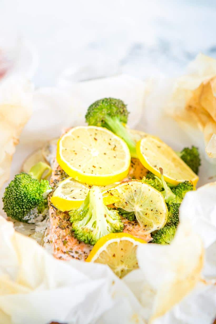 baked salmon, lemon slices, and broccoli in parchment paper