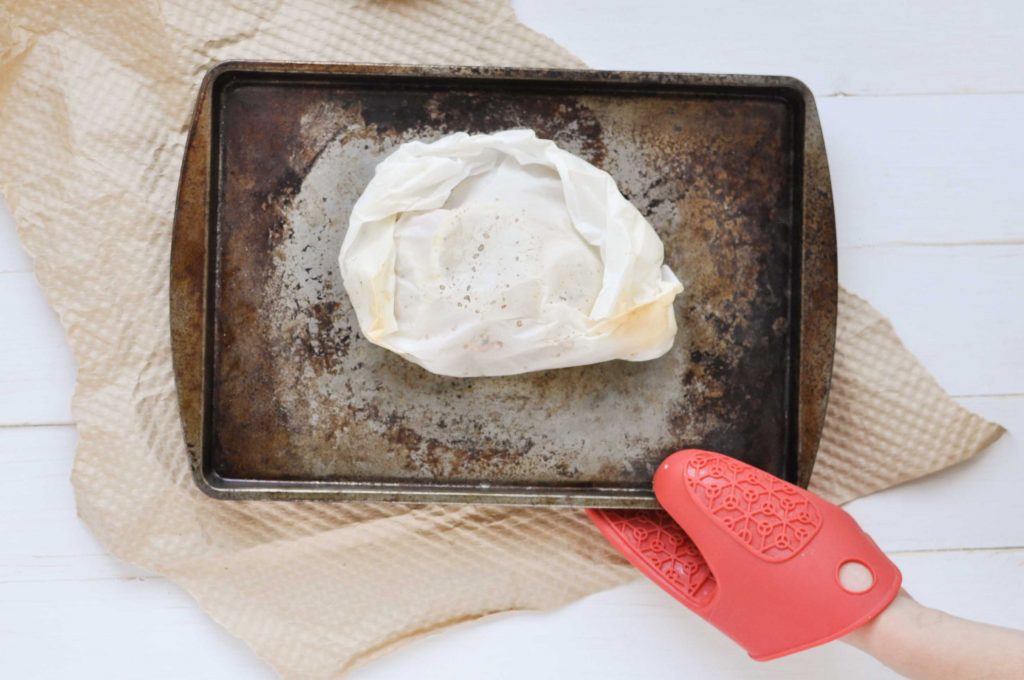 salmon in parchment paper on a baking sheet