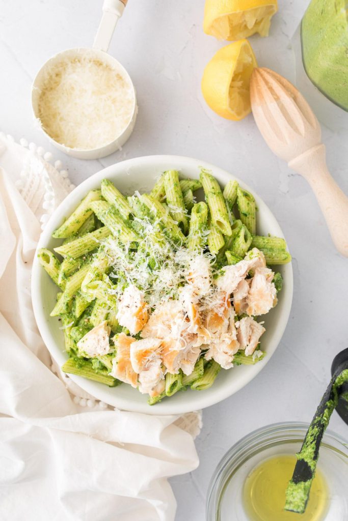 pistachio pasta with chicken on top with ingredients around it