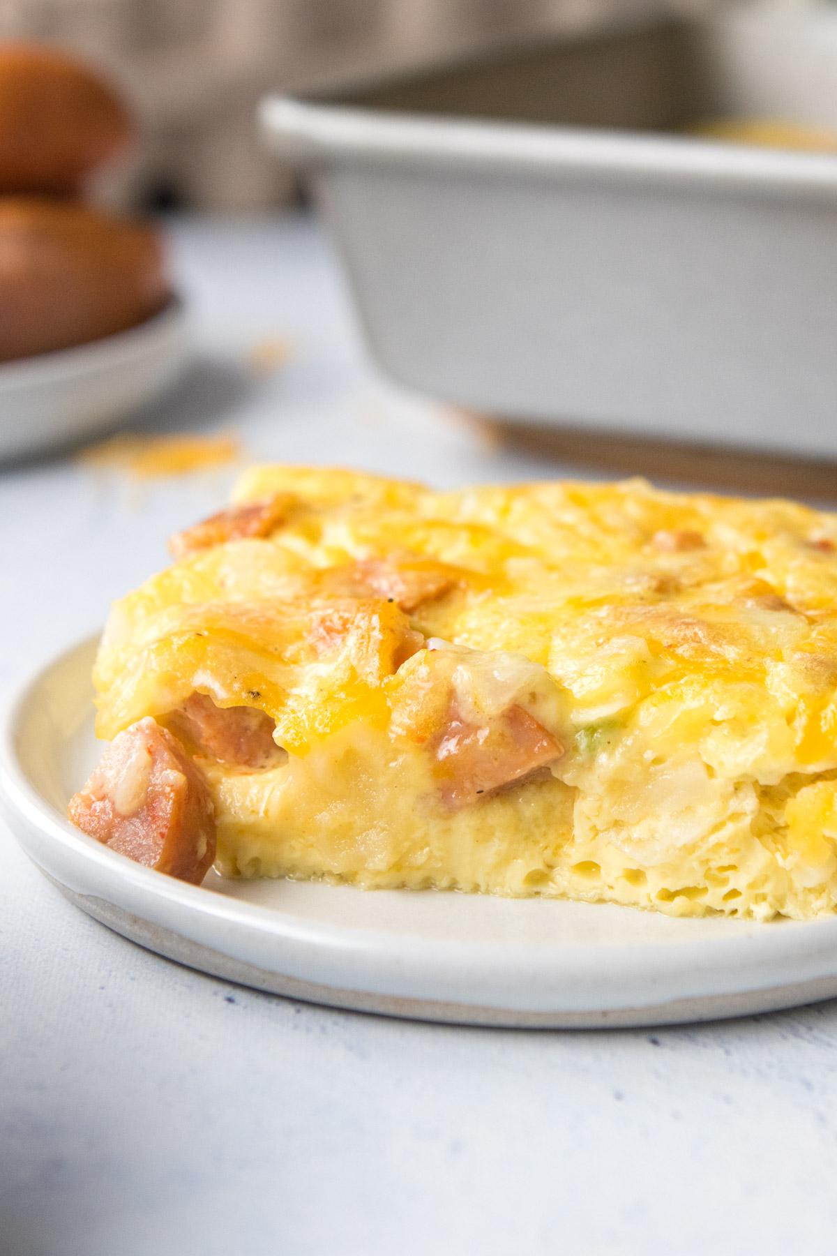 breakfast sausage casserole in glass baking dish on a blue and white striped towel