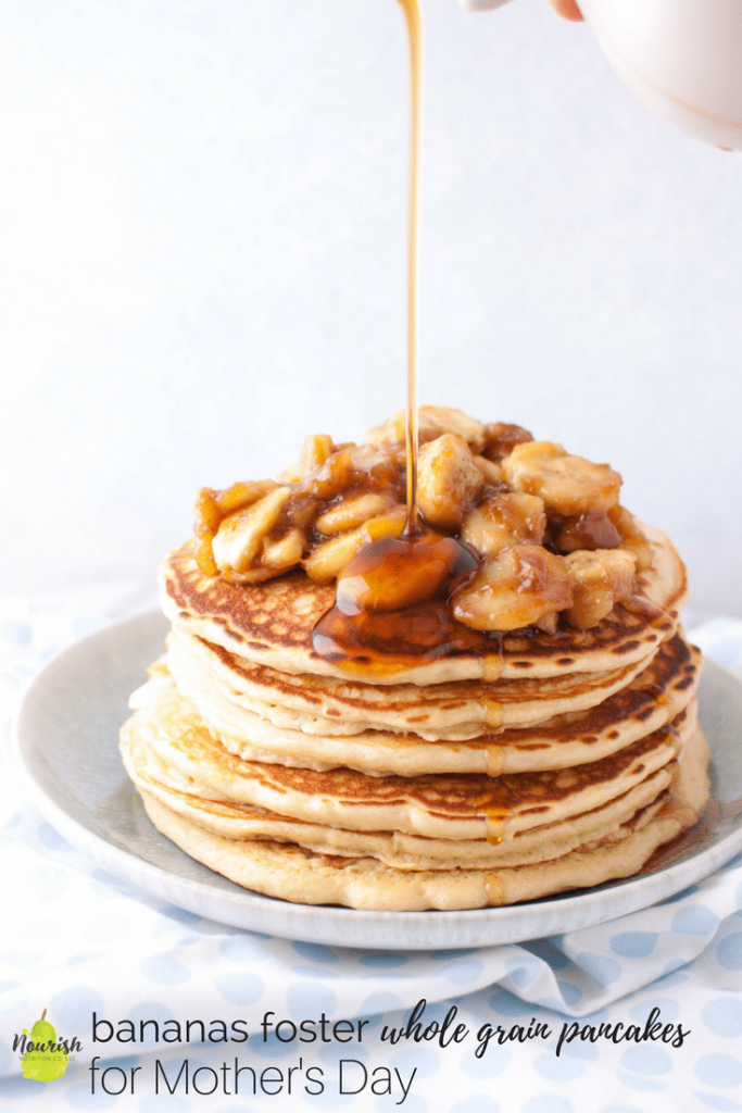 pouring maple syrup over bananas foster pancakes