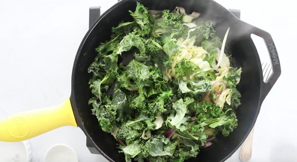 sauteed kale salad in cast iron skillet with spatula