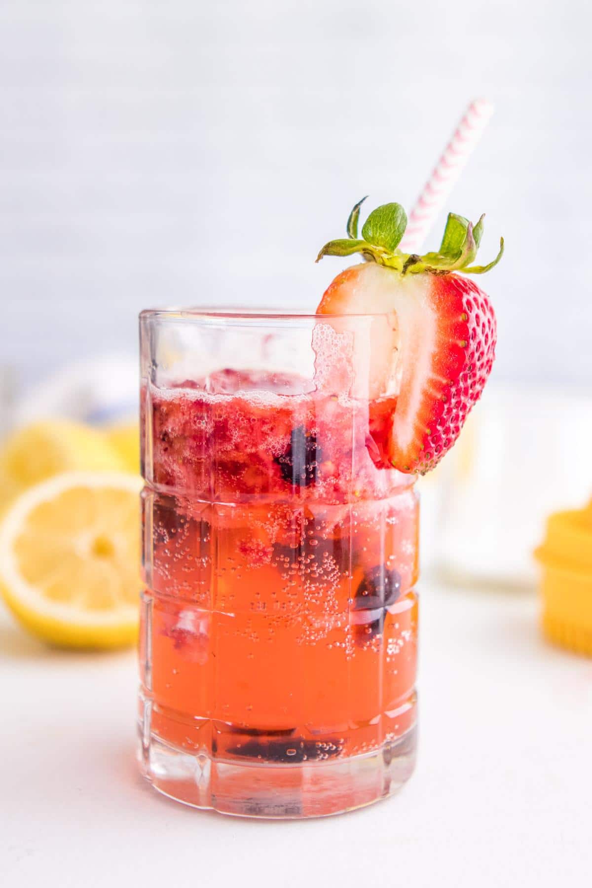 one glass of sparkling berry lemonade with a strawberry on the rim