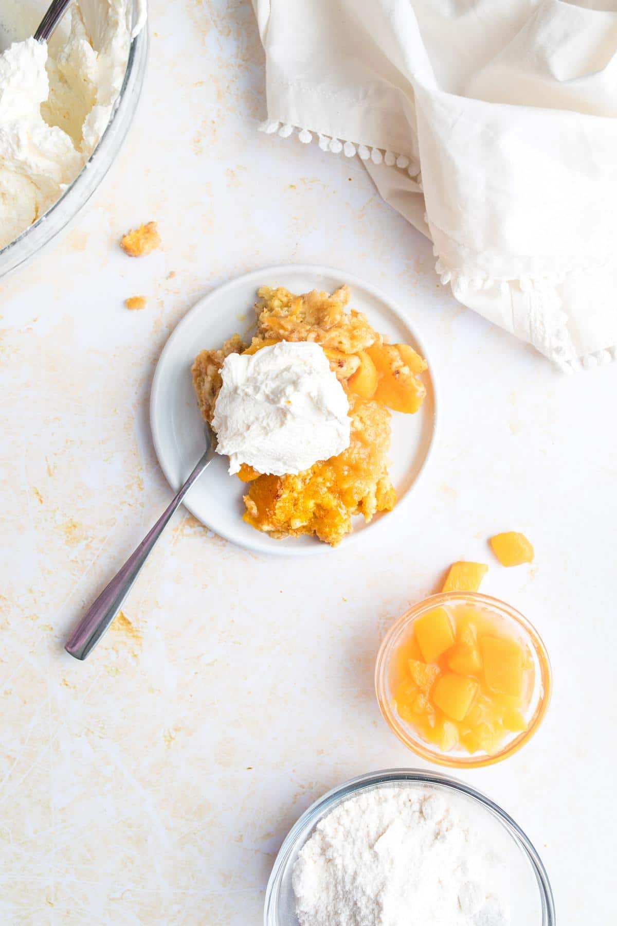 plate of peach cobbler with fork, ingredients around it