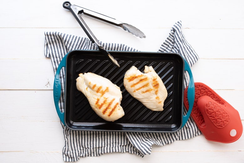 two chicken breasts on a grill pan