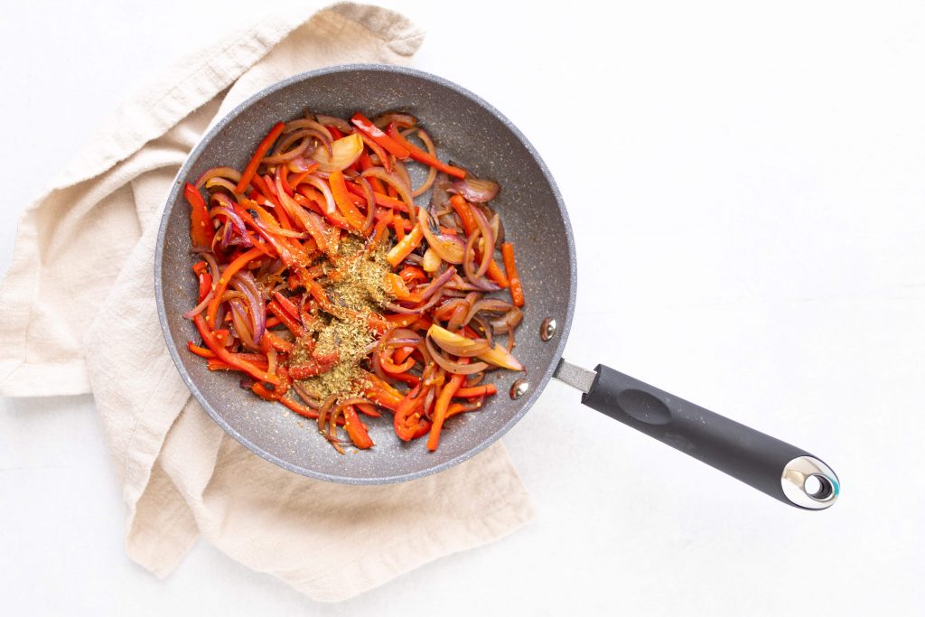 red bell pepper and onions with spices in sautee pan