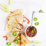 black bean & vegetable quesadilla on table with salsa and toppings