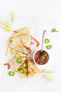 black bean & vegetable quesadilla on table with salsa and toppings