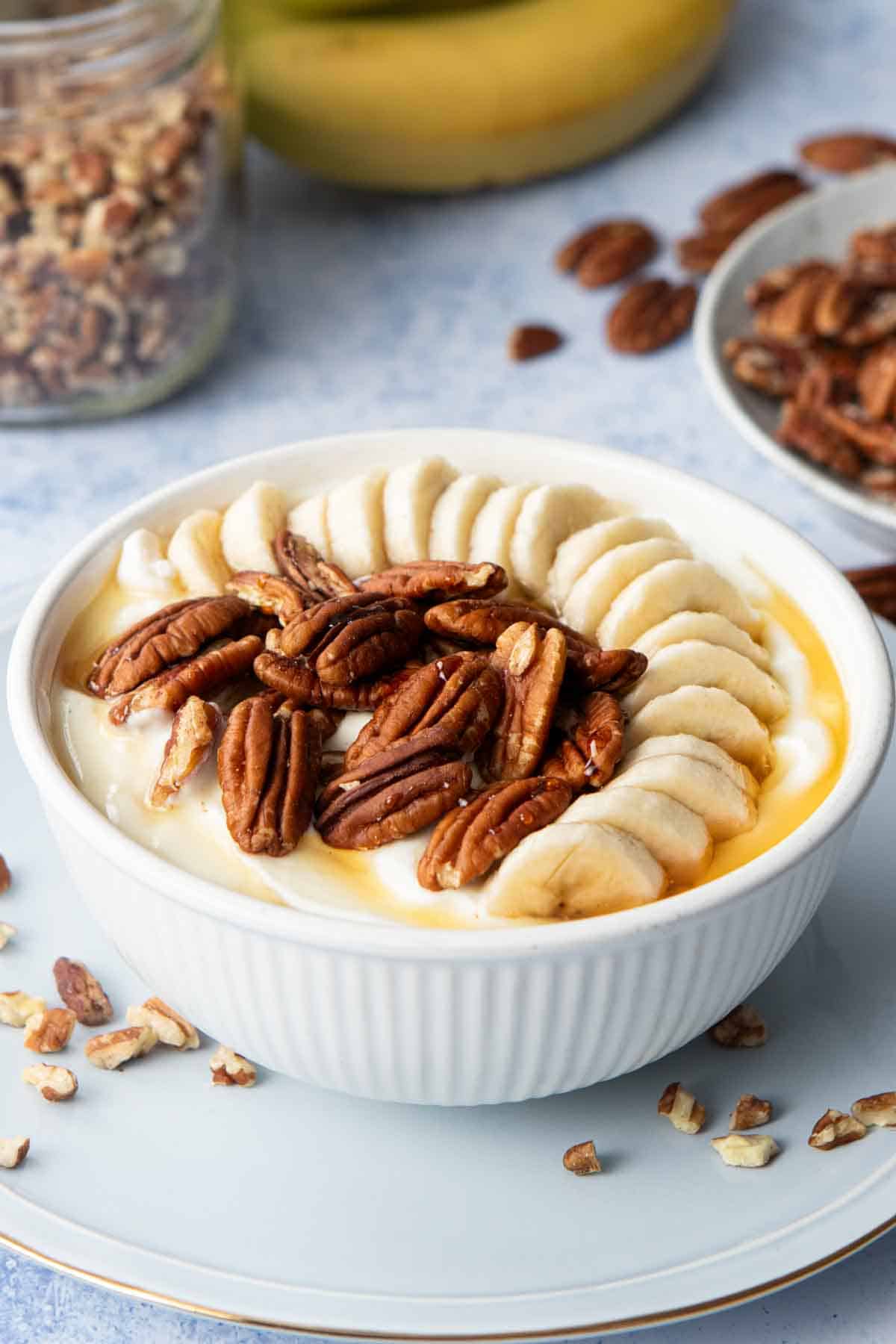 yogurt bowl with sliced bananas and pecans on top