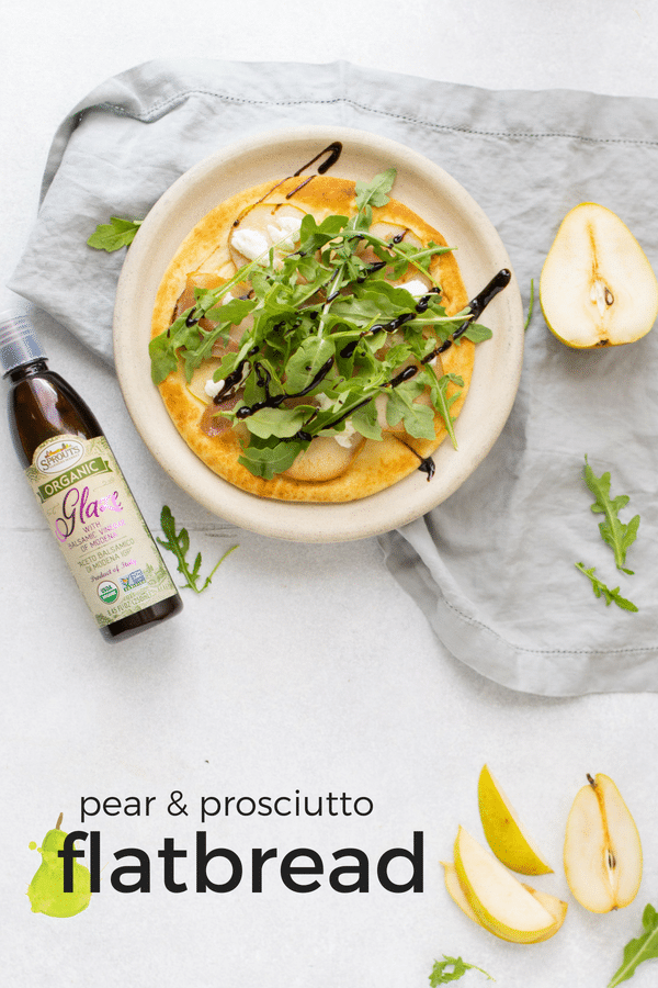 pear prosciutto and arugula flatbread with pears and balsamic glaze on table with text overlay