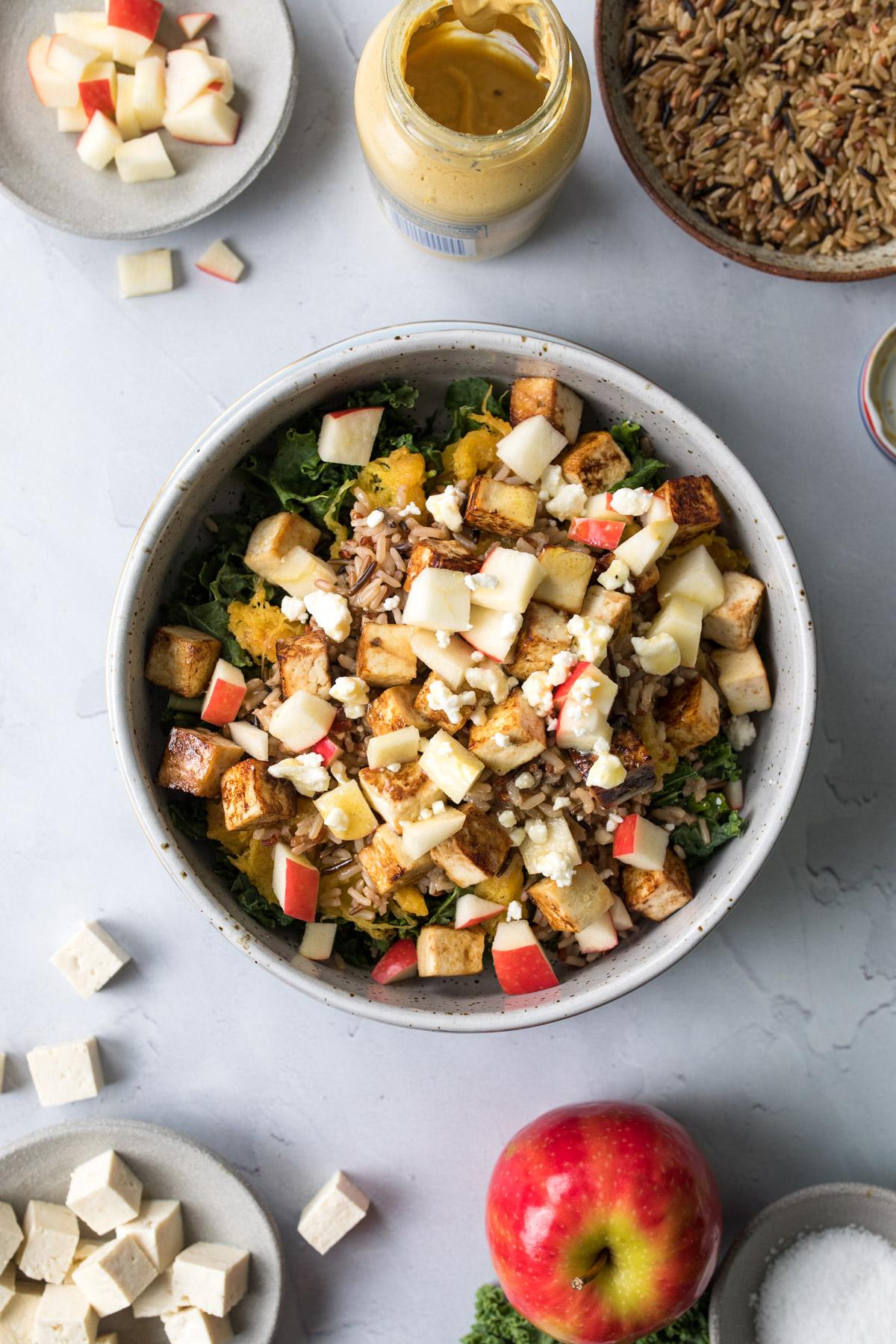 This warm harvest bowl with apples and maple glazed tofu includes all the classic fall flavors into this easy and nourishing vegetarian bowl. It's perfect for meal prep and lunch #vegetarian #fall #harvestbowl #wintersquash