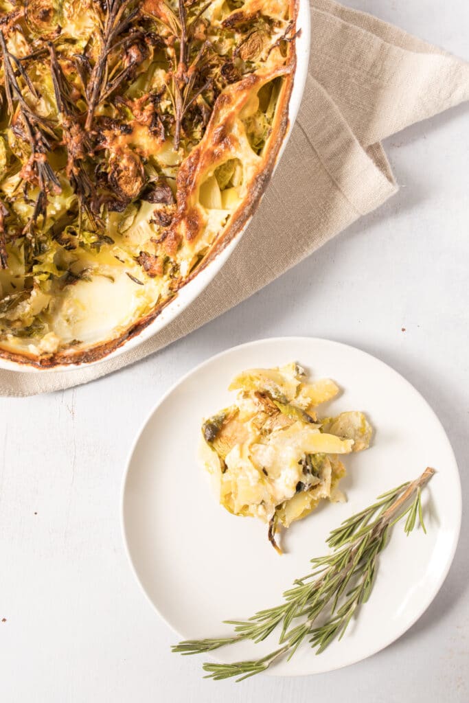 rustic potato and brussels sprouts au gratin on plate with pan on table