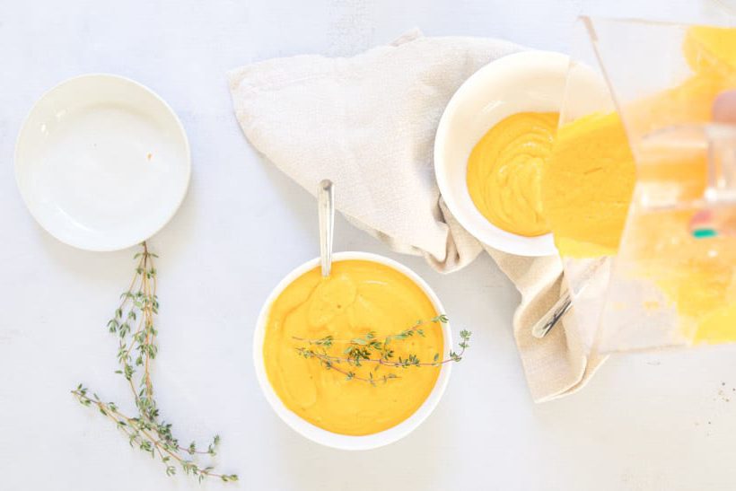 pouring instant pot sweet potato soup into bowl