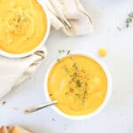 instant pot sweet potato soup with tofu in bowls, on table with bread