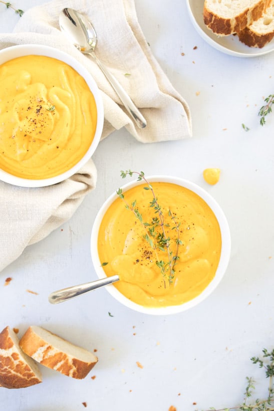 easy esweet potato soup with tofu in bowls, on table with bread