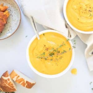 bowl of sweet potato soup with thyme garnish