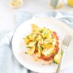 skillet pork chops with apples and vegetables on a white plate