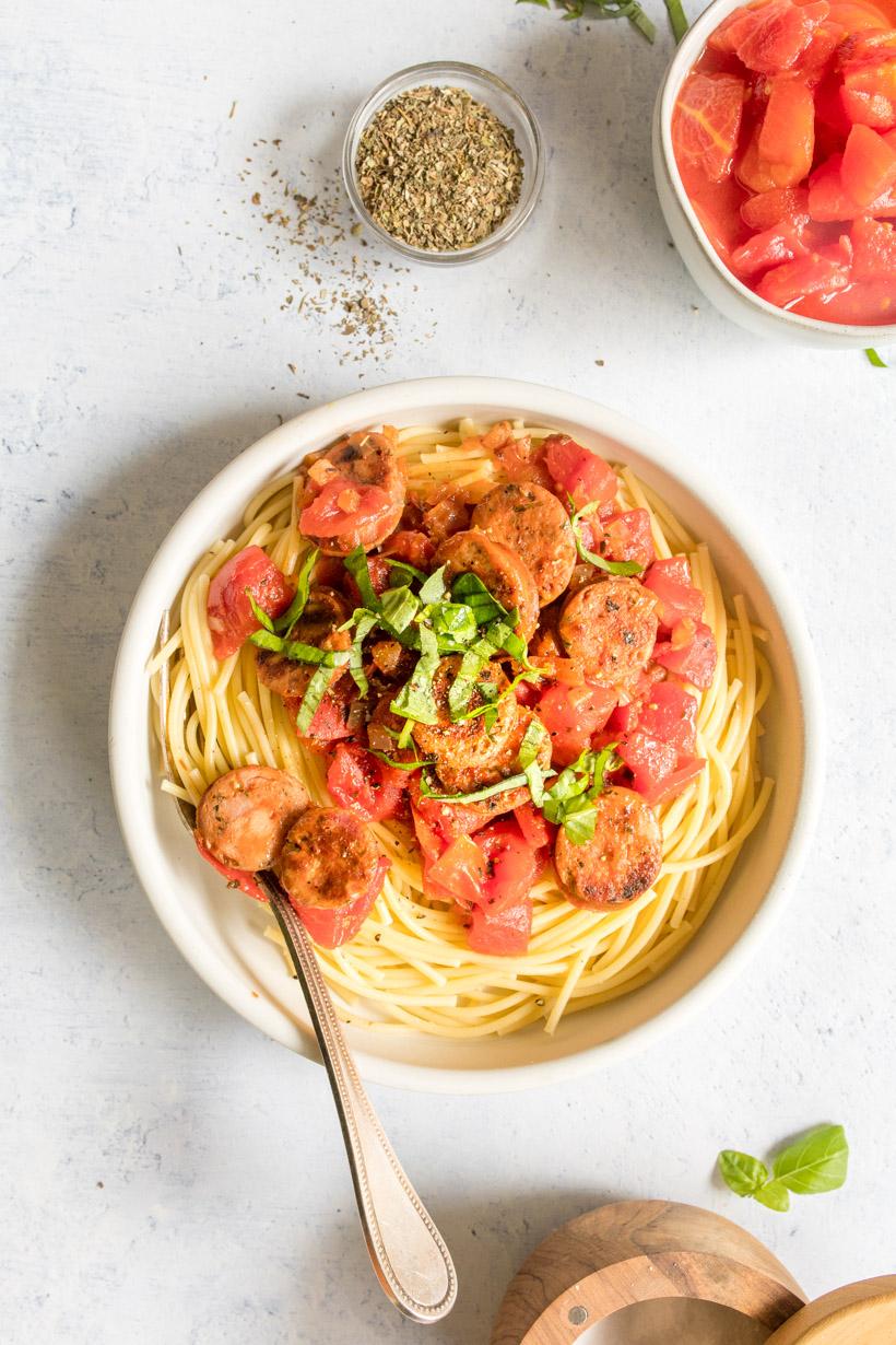 Simple pasta in a bowl on a table with other ingredients