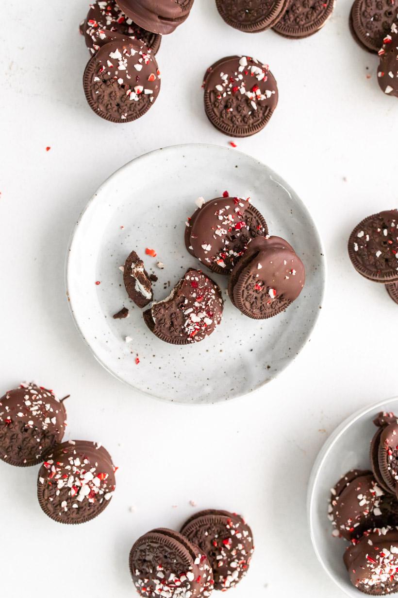 Oreos with chocolate and peppermint on a plate and the table 