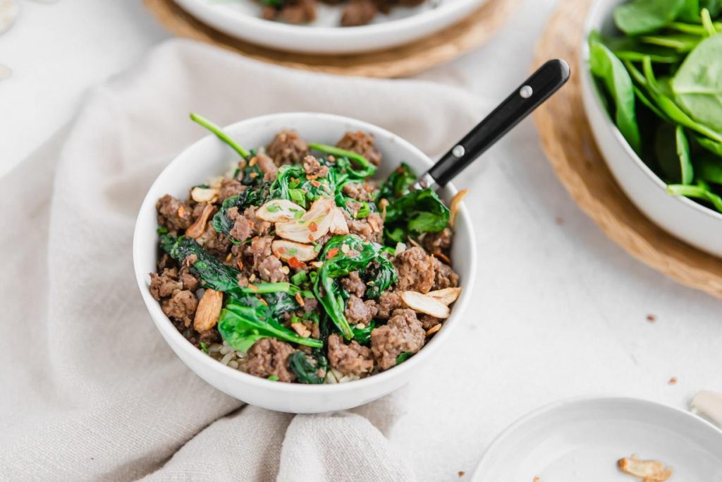 Thai beef bowl with a fork in it, on a table