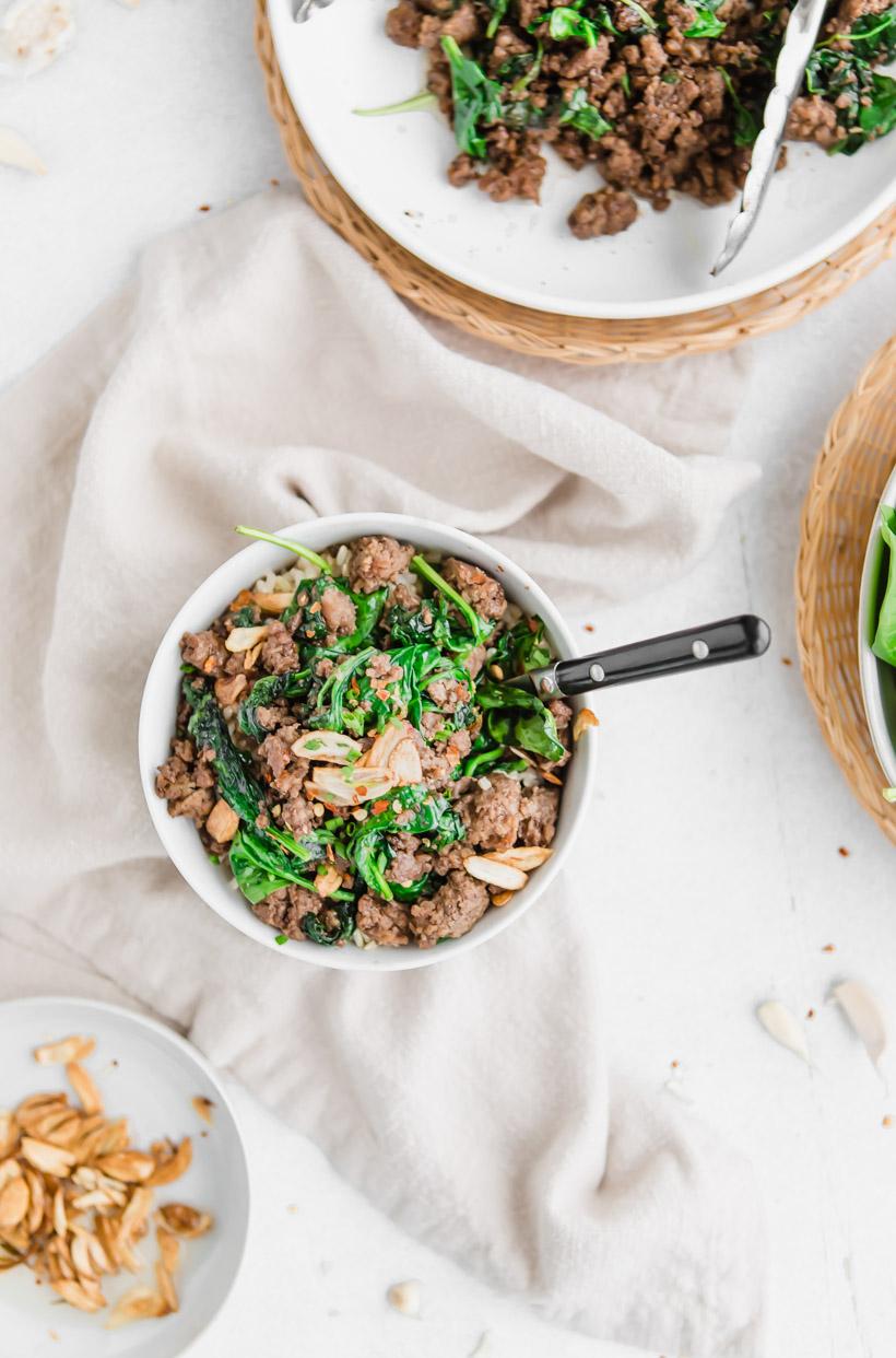 beef and spinach with sliced garlic in a bowl