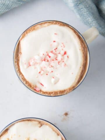 mug with hot chocolate, cream, crushed peppermint