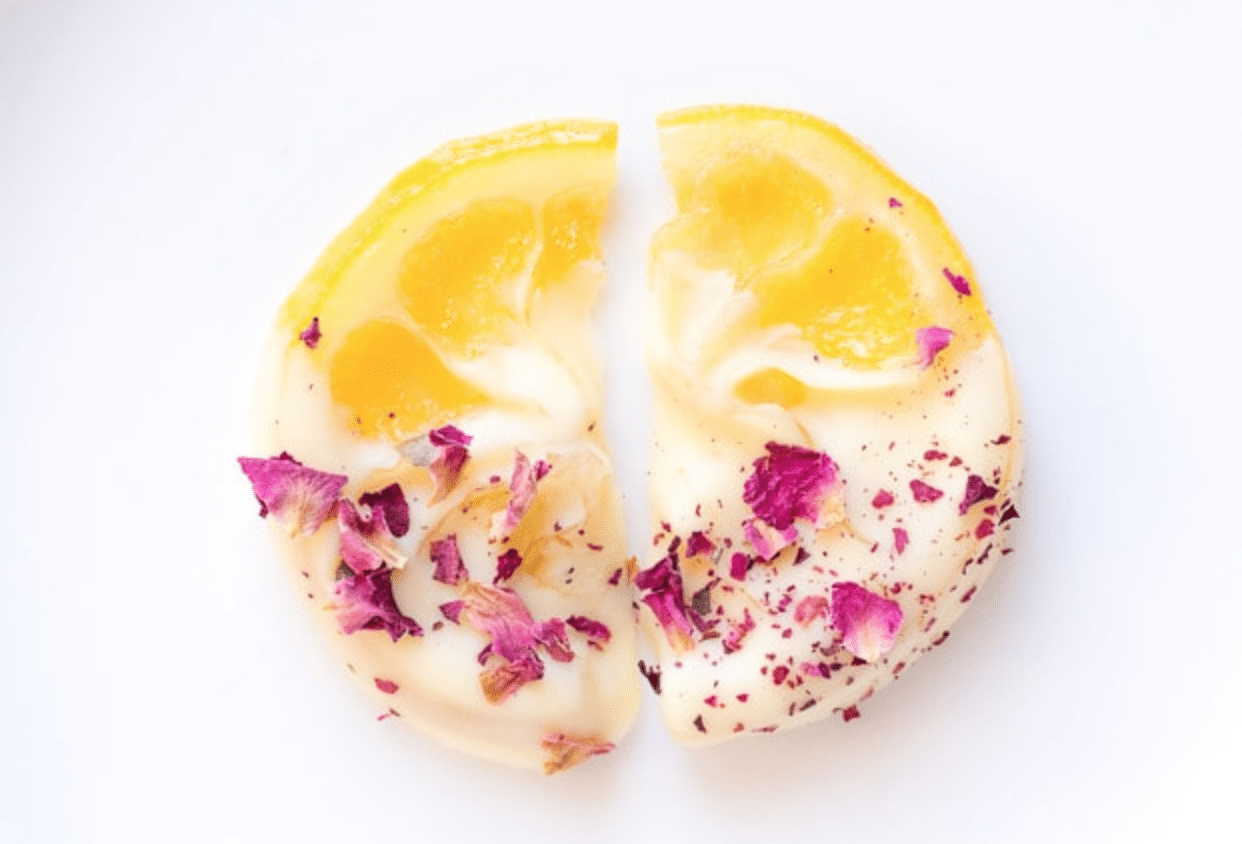 two slices of dried lemon with white chocolate and dried flower petals on top