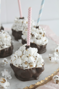 chocolate popcorn balls with straws in them on a plate