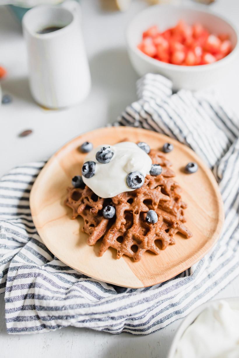 chocolate waffle with whipped cream and blueberries on a plate for a DIY waffle bar