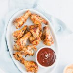 Asian BBQ Chicken Wings Recipe on a plate with dipping sauces