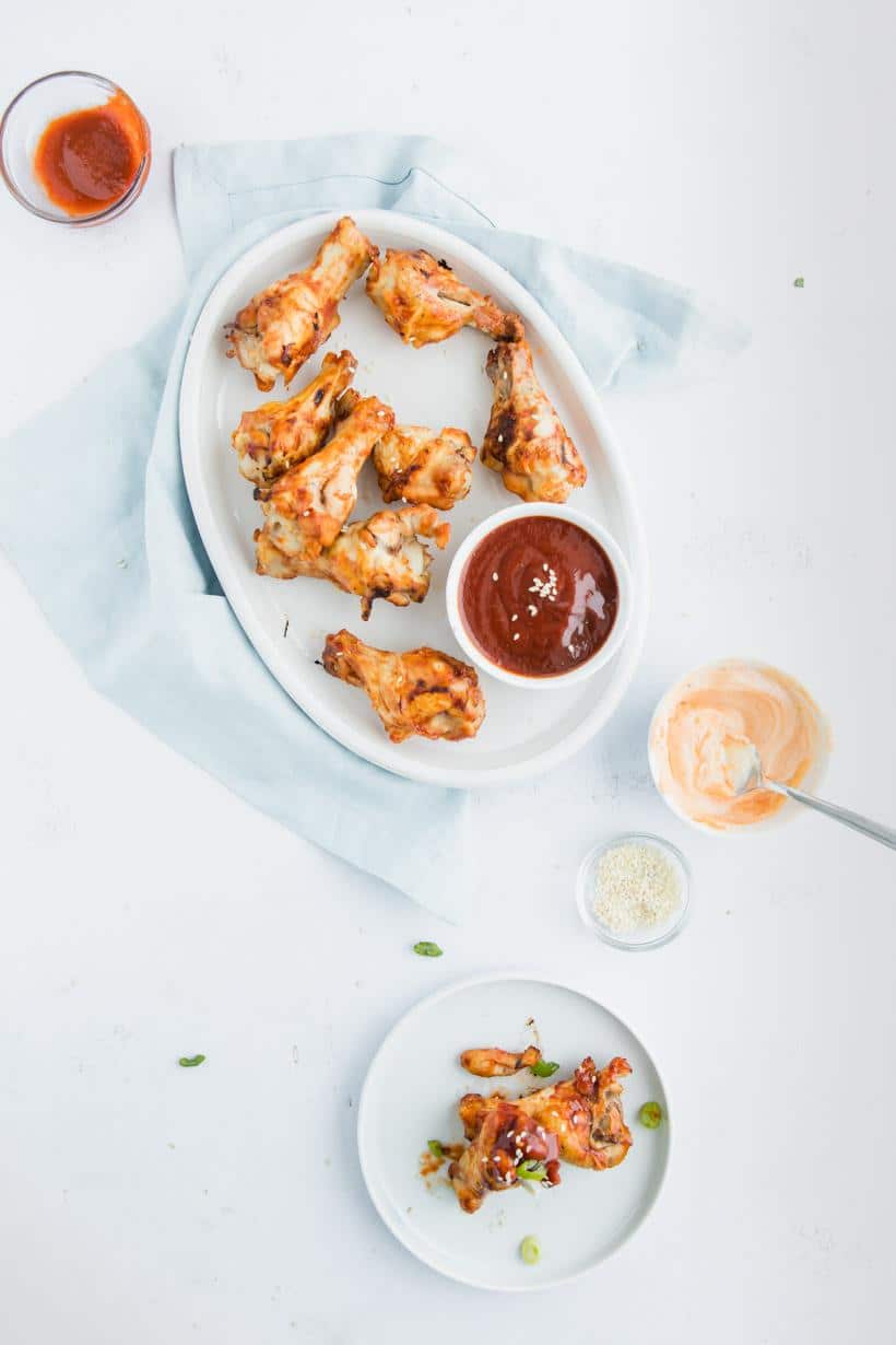 Asian BBQ Chicken Wings Recipe on a table with dipping sauces