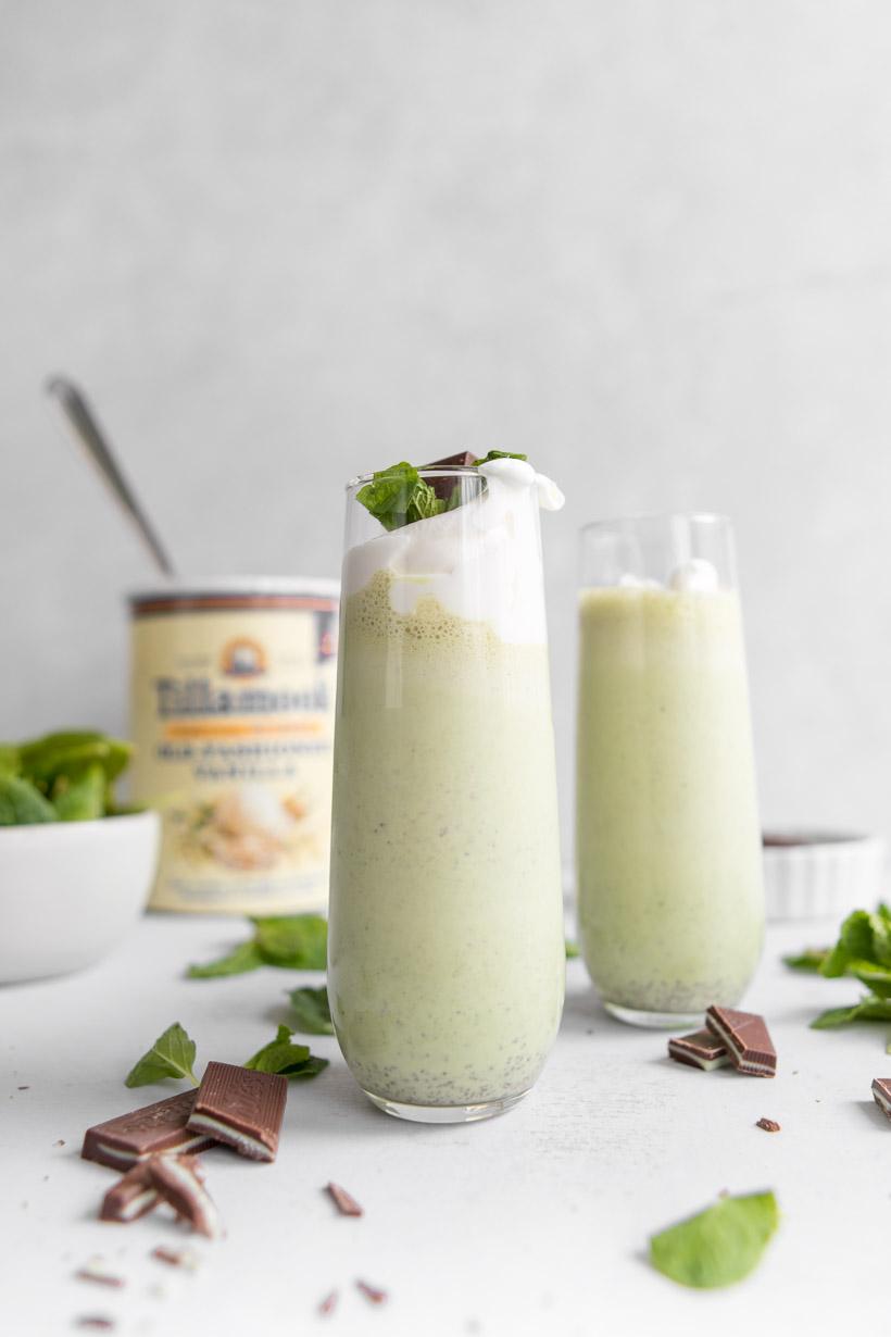 homemade shamrock shake in a tall glass with ingredients in the background