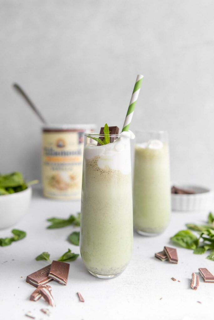 homemade shamrock shake with green straw and ingredients in the background