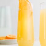 mimosa mocktail in a glass with an orange