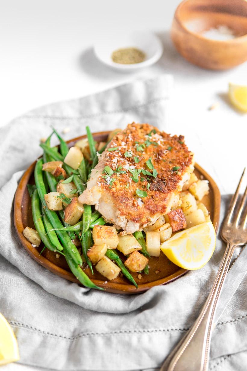 Panko pork chop with green beans and potatoes on a brown plate