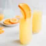 orange juice in glass with large orange slice