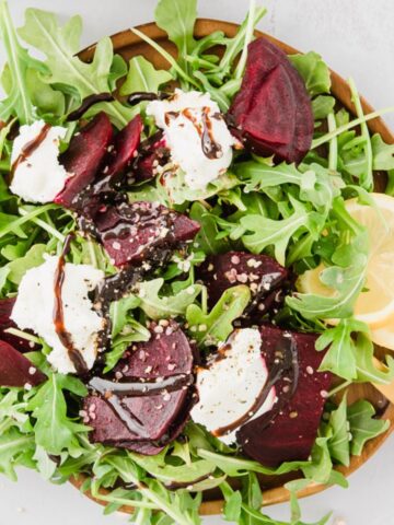 close up of beets, cheese, arugula, lemons on plate