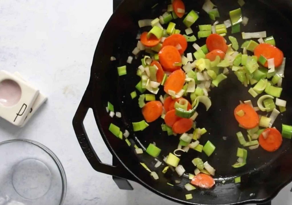 vegetables for white bean and farro bowl cooking in cast iron skillet