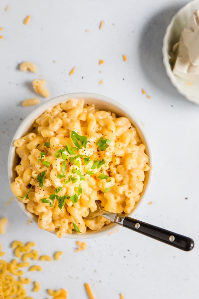 protein mac and cheese in a bowl with a fork in it