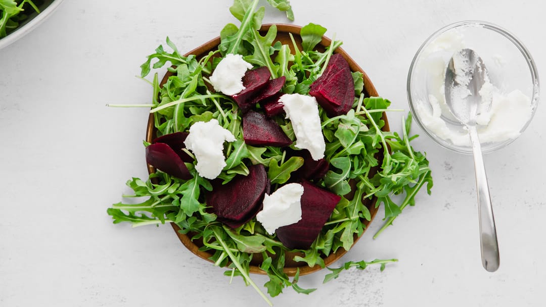 arugula, beets, and goat cheese on a plate