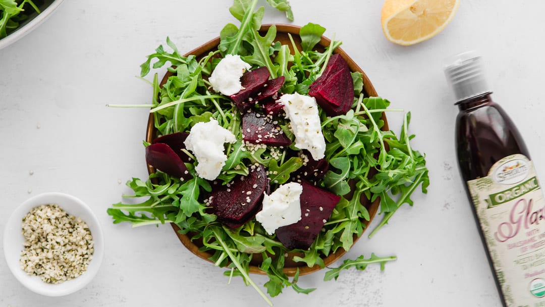 arugula, beets, goat cheese, and hemp hearts on a plate