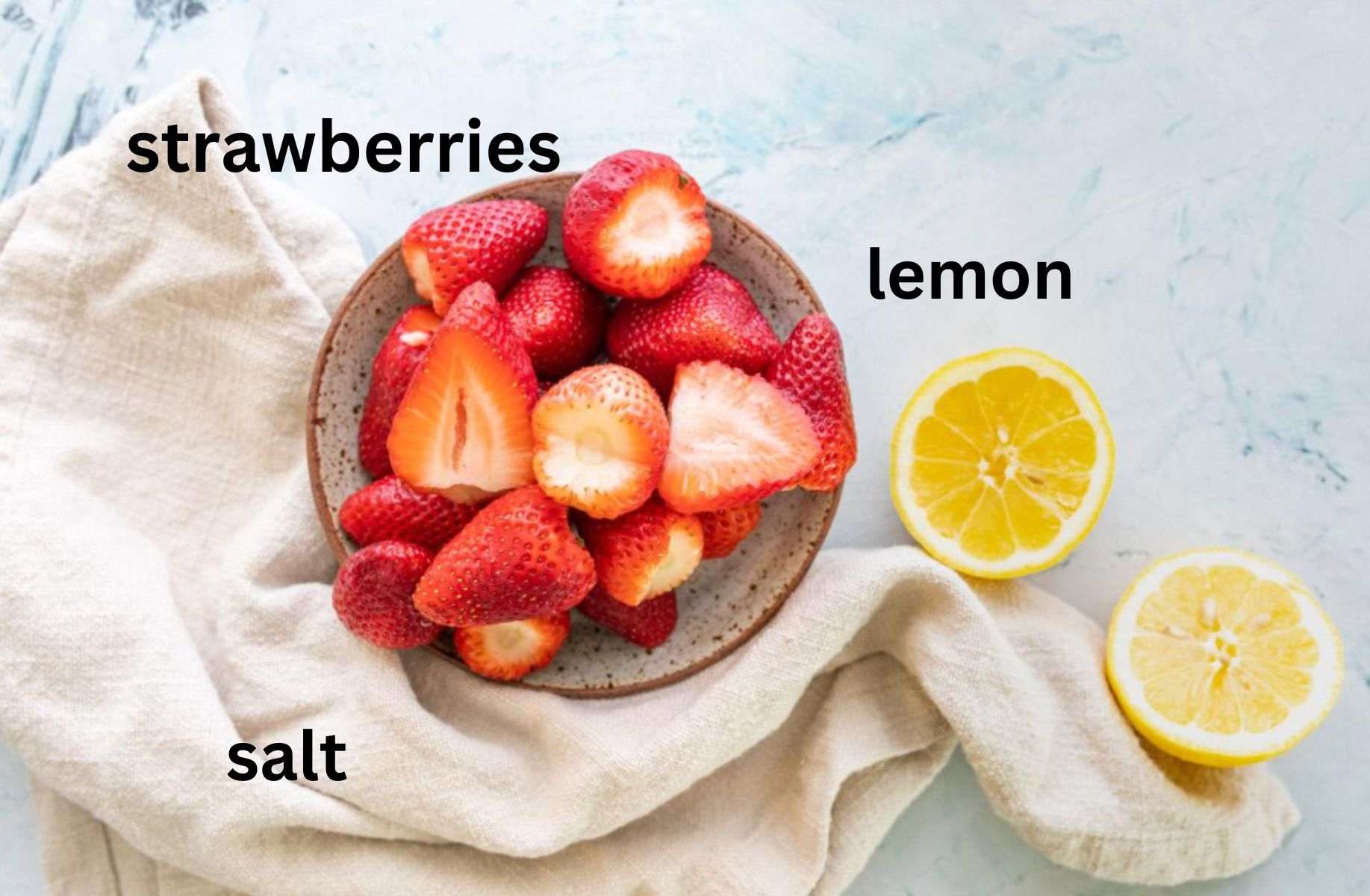 cut strawberries on a plate with lemon slices on a table